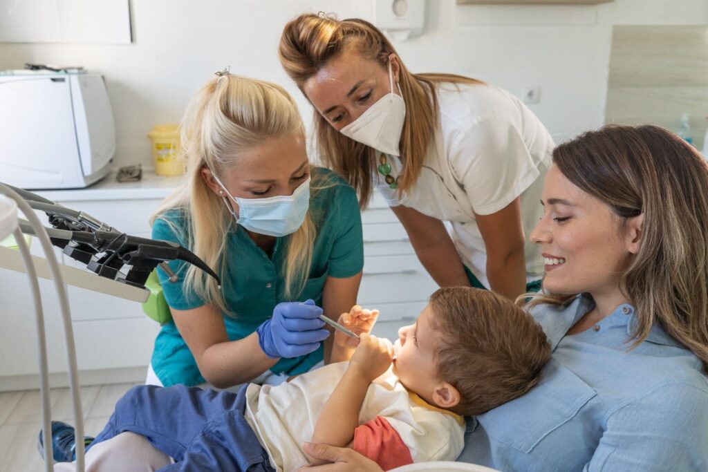 Young boy sitting with mom during a family dental checkup in Sarasota, supported by friendly dentists for stress-free care.