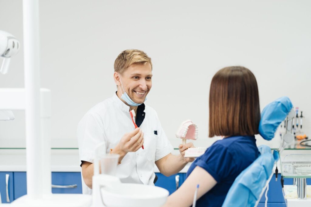 Dentist in Bradenton, Florida, explaining dental hygiene steps during a first visit, helping patients understand the dentist visit cost and care options.
