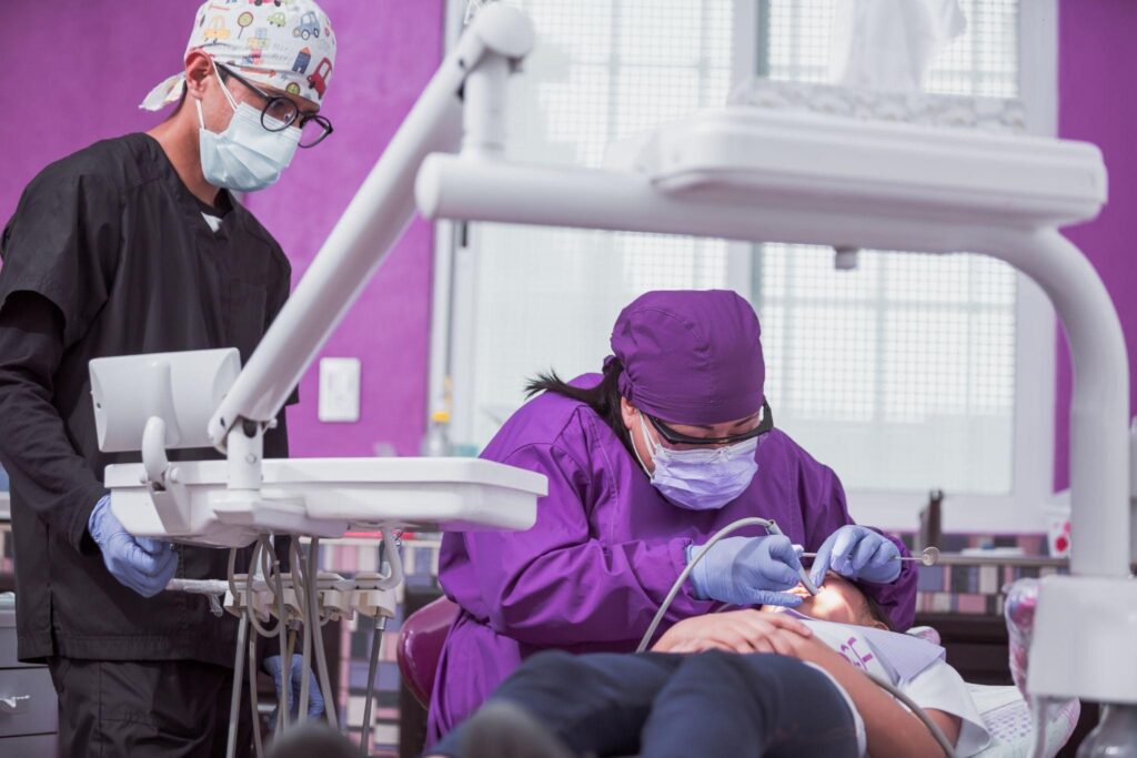 Dentist performing restorative dental treatment on a patient in a modern clinic, showcasing dental restorative services in a supportive and professional environment.