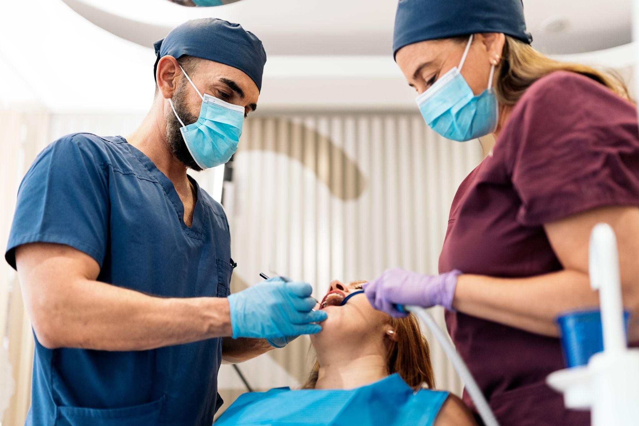 Cosmetic dentist in Bradenton performing a dental procedure with an assistant helping a patient in the chair.