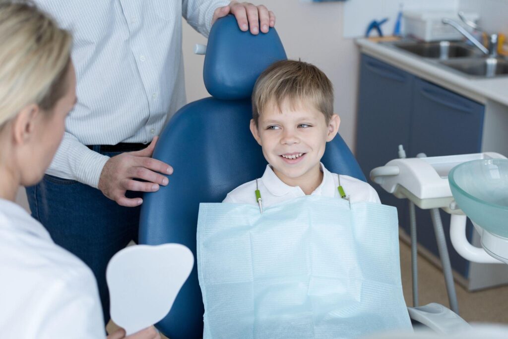 Smiling young boy at a Sarasota family dental clinic during his routine check-up with a friendly dentist, feeling comfortable in a child-friendly dental chair.