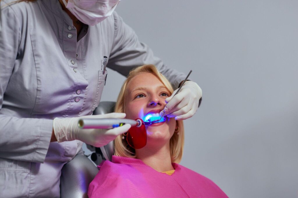 Patient receiving in-office teeth whitening using ultraviolet light by a dental professional in Sarasota FL